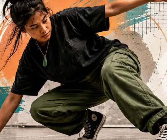 A dancer mid-movement in front of a painted mural