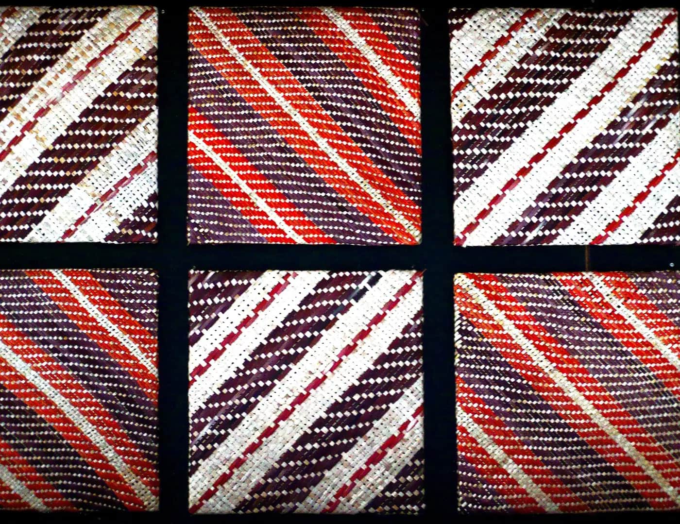 Six square woven panels in red, white and dark purple, each with bold diagonal stripes, set in a black frame