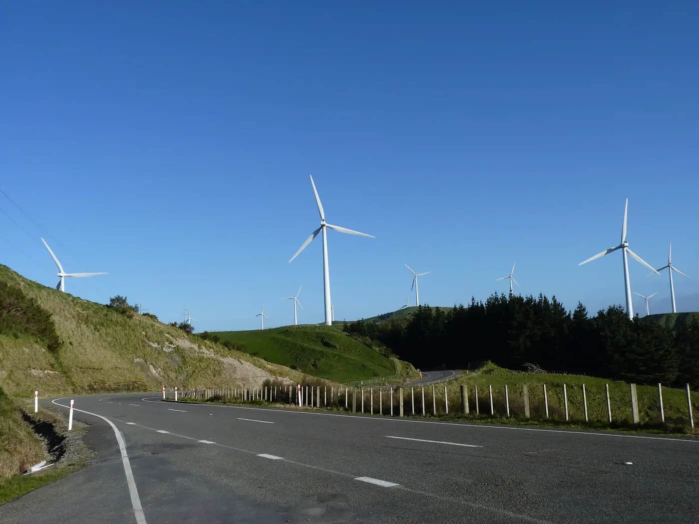 Tall white wind turbines on green hills at Te Āpiti wind farm near the Manawatū Gorge