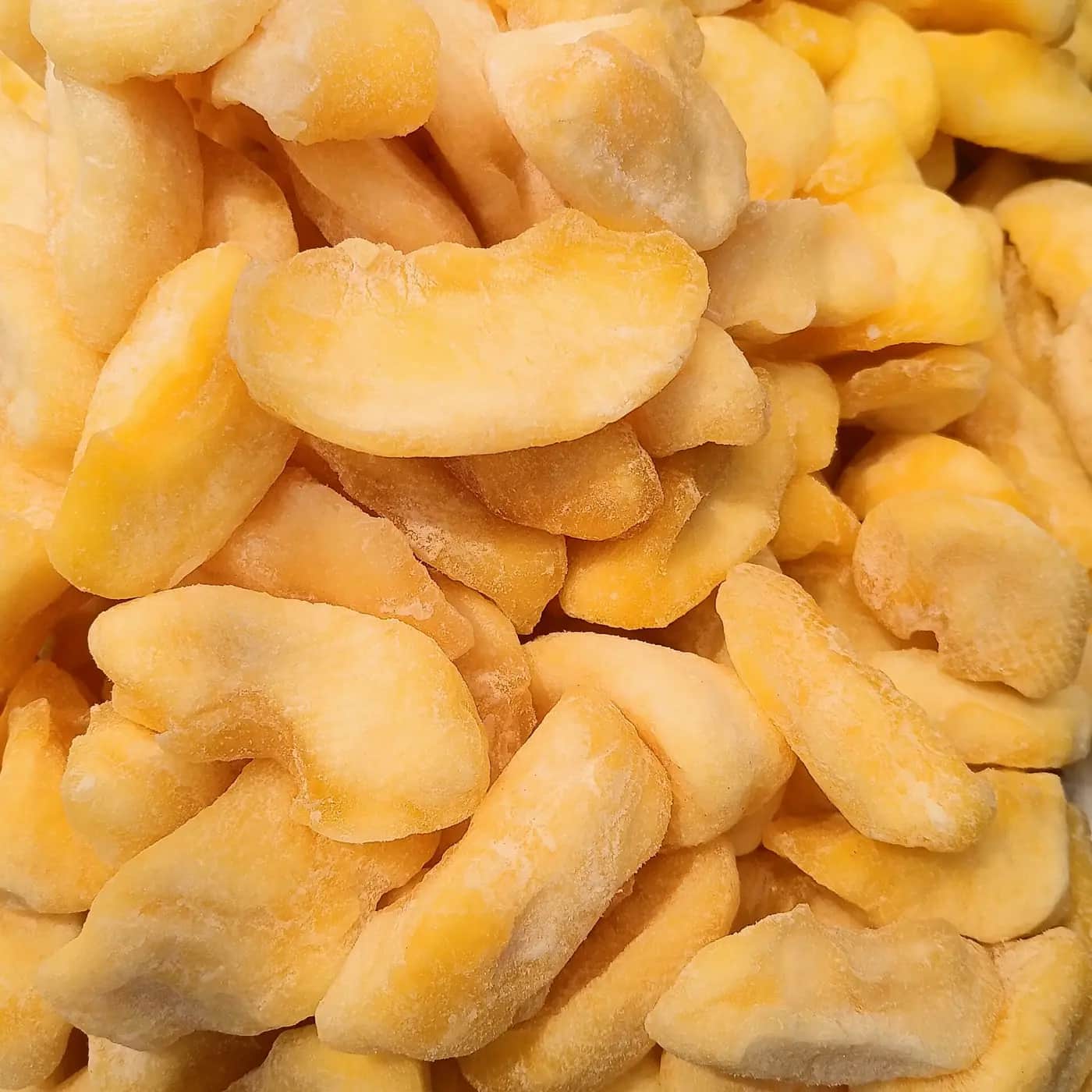 A close-up pile of pale yellow dried apple slices